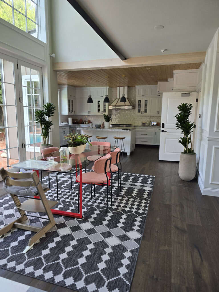 Modern dining room and kitchen with professionally styled indoor plants, including tall dracaena plants in decorative planters, enhancing residential interiorscaping design.